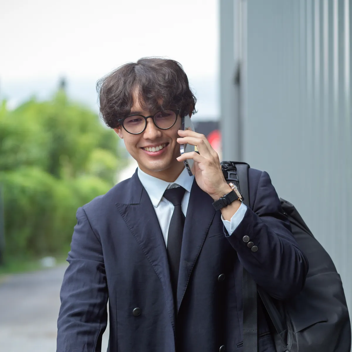 야외에서 정장 차림으로 휴대폰 통화를 하는 사람